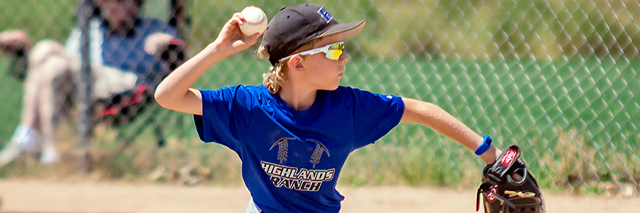 A young baseball player winds up to pitch.