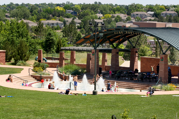 Kids and adults play in the interactive fountains in front of Case Pavilion at Civic Green Park.