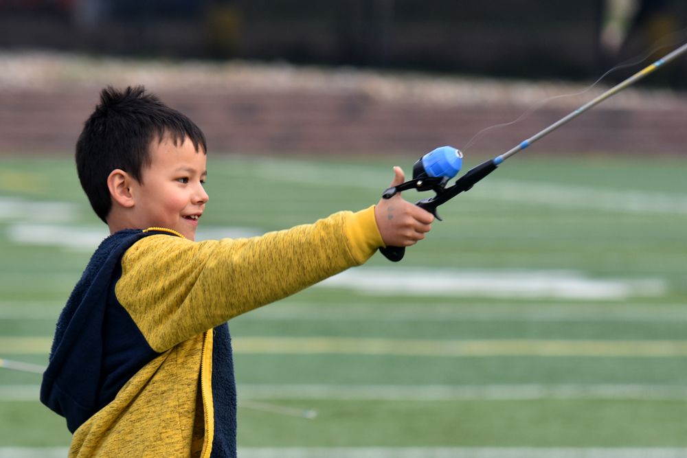 Young boy learning to cast a fishing rod