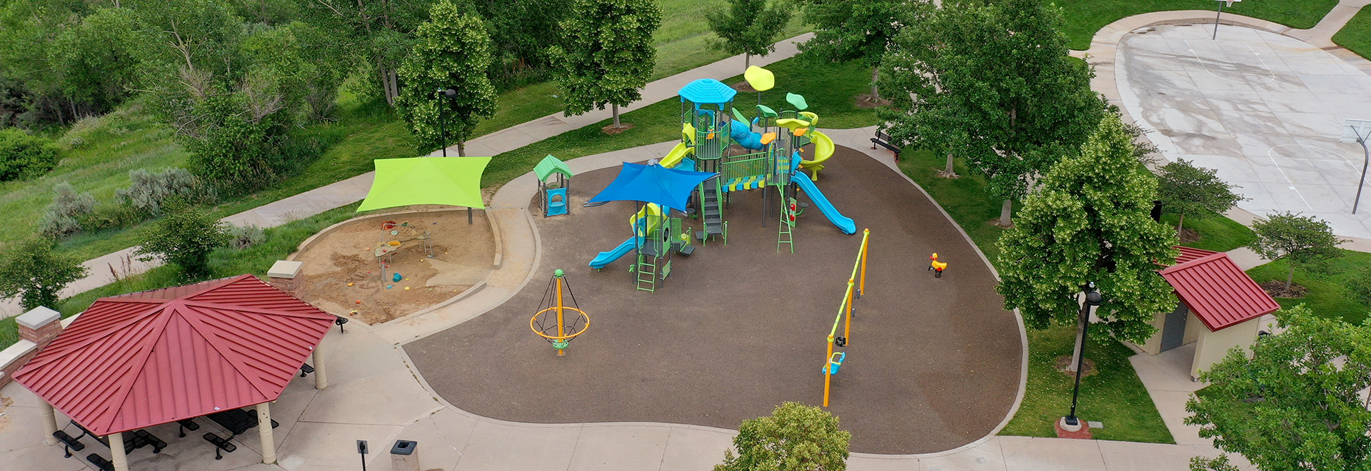 Aerial view of Dad Clark Playground's picnic shelter, sand play area, and playground equipment.