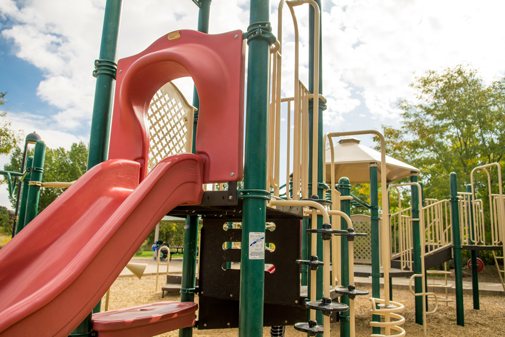 A slide with other playground equipment at Big Dry Creek Park in the background