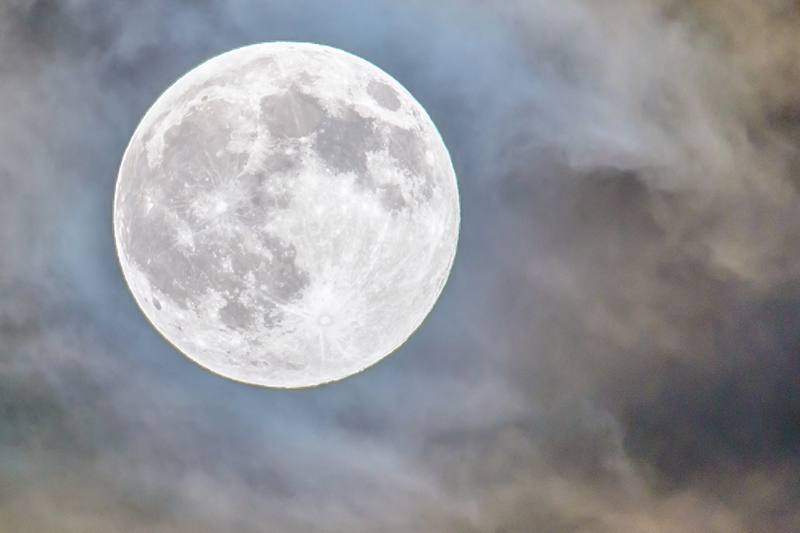 Full moon in cloudy night sky