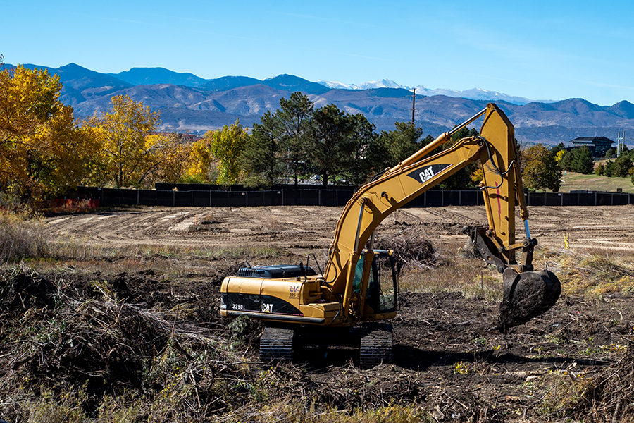 A large earth mover performs site work.